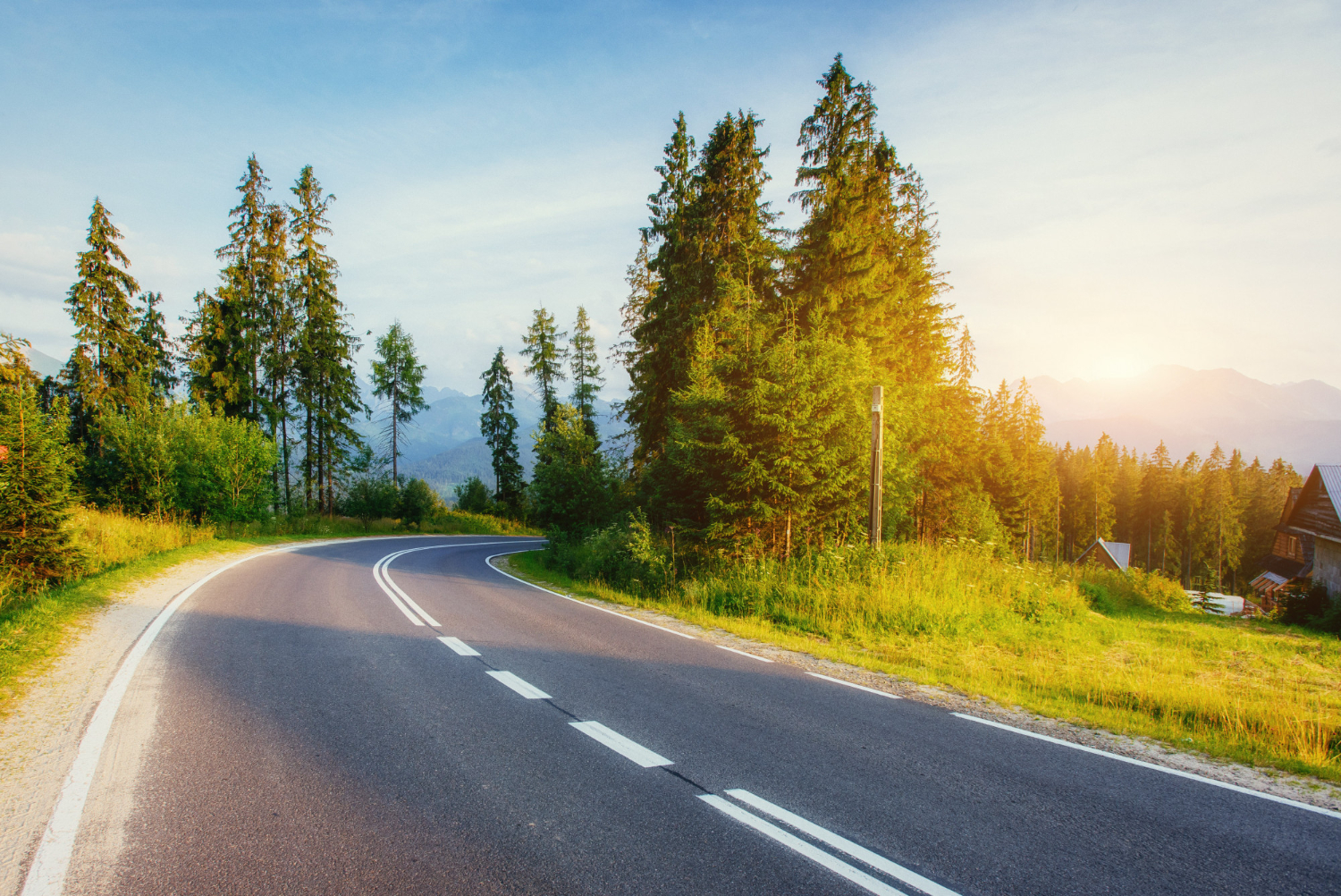 road-leads-through-woods-mountains-sunset